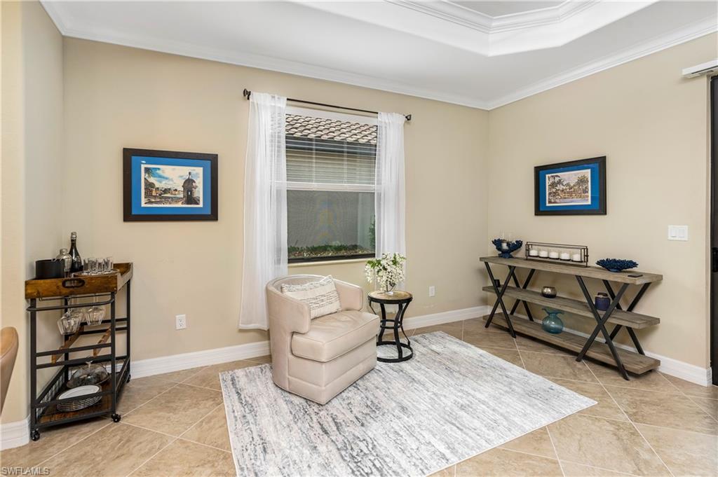 Living area featuring crown molding and light tile patterned flooring