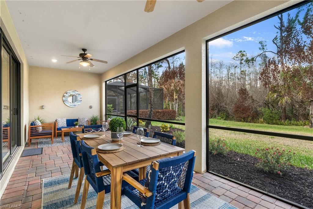 Sunroom / solarium with a ceiling fan, outdoor dining space, and a patio