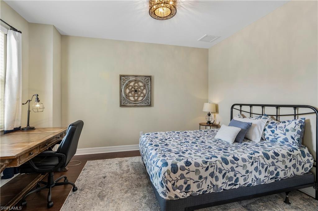 Bedroom with dark wood-type flooring and a desk