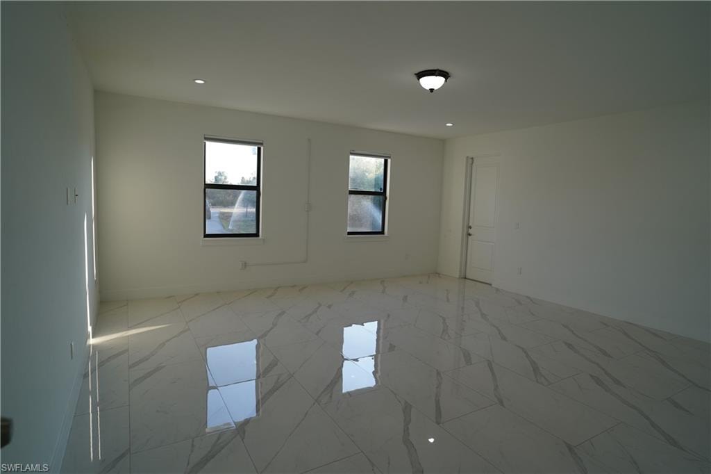 Unfurnished room featuring recessed lighting and baseboards