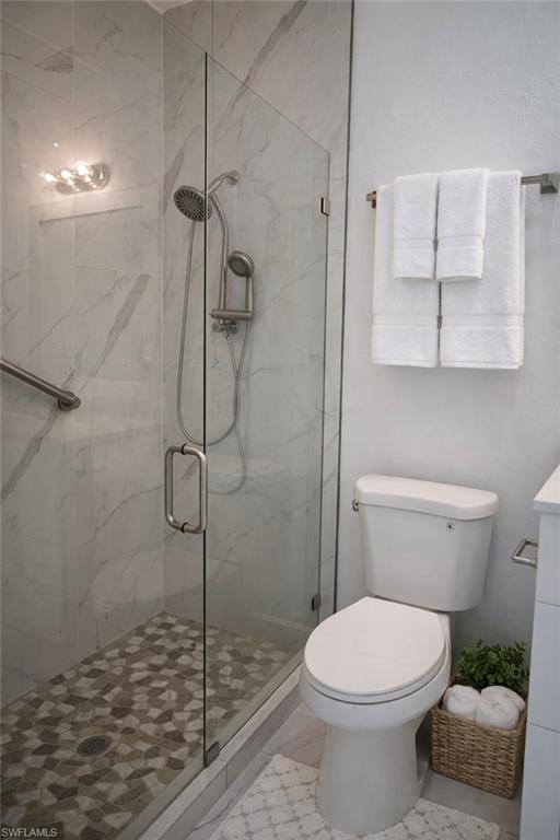 Bathroom with a marble finish shower and vanity