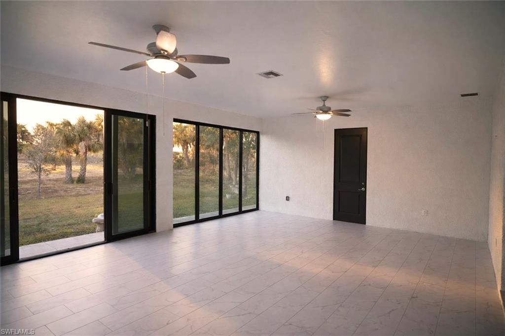 Unfurnished room featuring ceiling fan and a textured wall