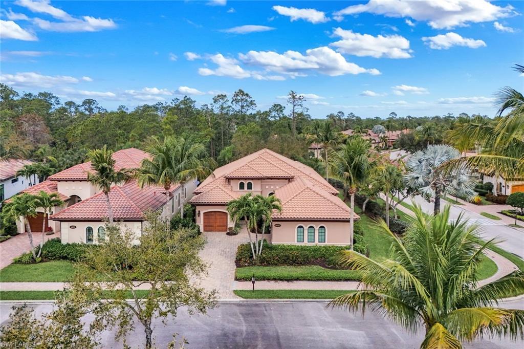 Mediterranean / spanish home featuring stucco siding, a tile roof, and curved driveway