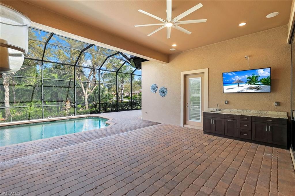 Swimming pool featuring a patio area, a sunroom, and glass enclosure