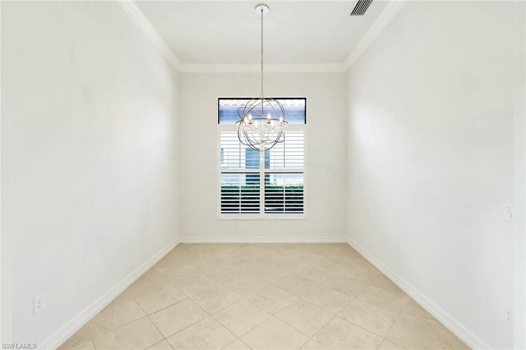 Unfurnished dining area featuring ornamental molding, light tile patterned floors, and suspended lighting