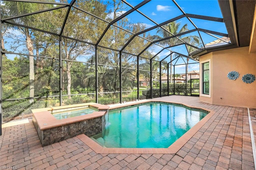 Relaxing pool / spa featuring a patio, a sunroom, and glass enclosure