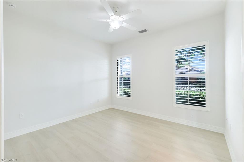 Empty room with light wood-style floors and ceiling fan