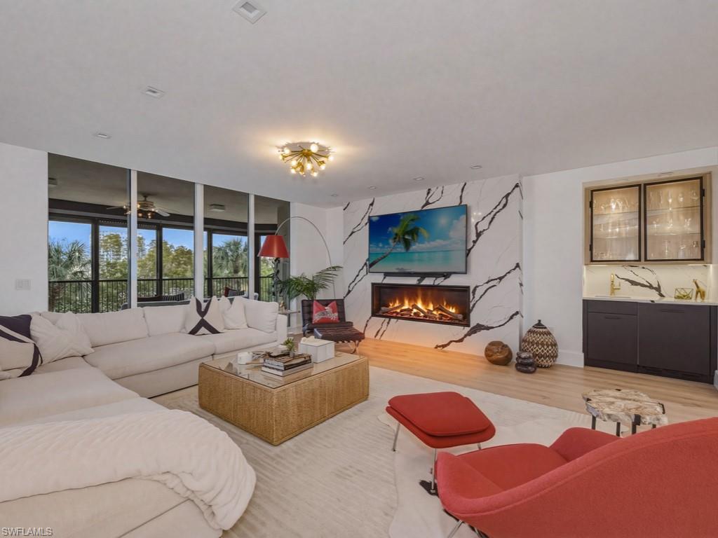 Living area featuring Legno Bastone wood finished floors, a fireplace with marble surround, and a coordinating wet bar
