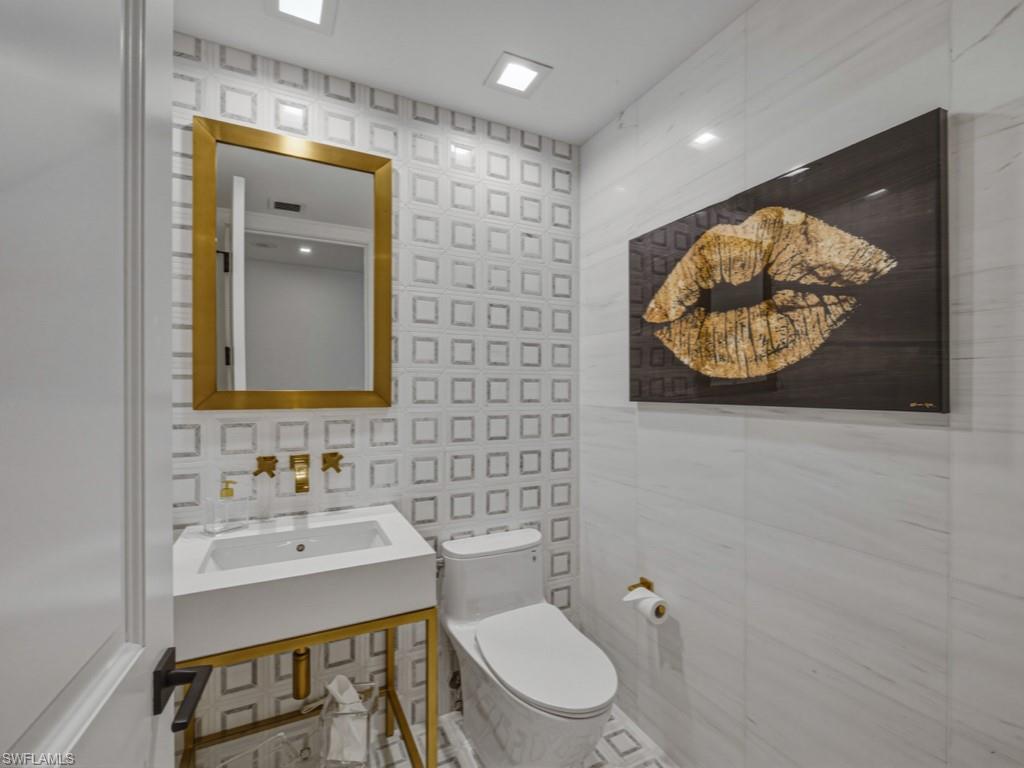 Bathroom with toilet and tile walls