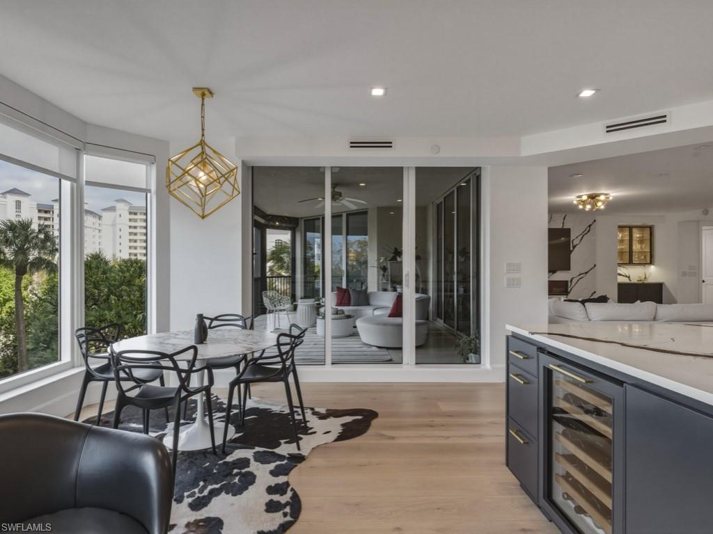 Dining room featuring Miele wine cooler, light wood-type flooring, suspended lighting, and ceiling fan