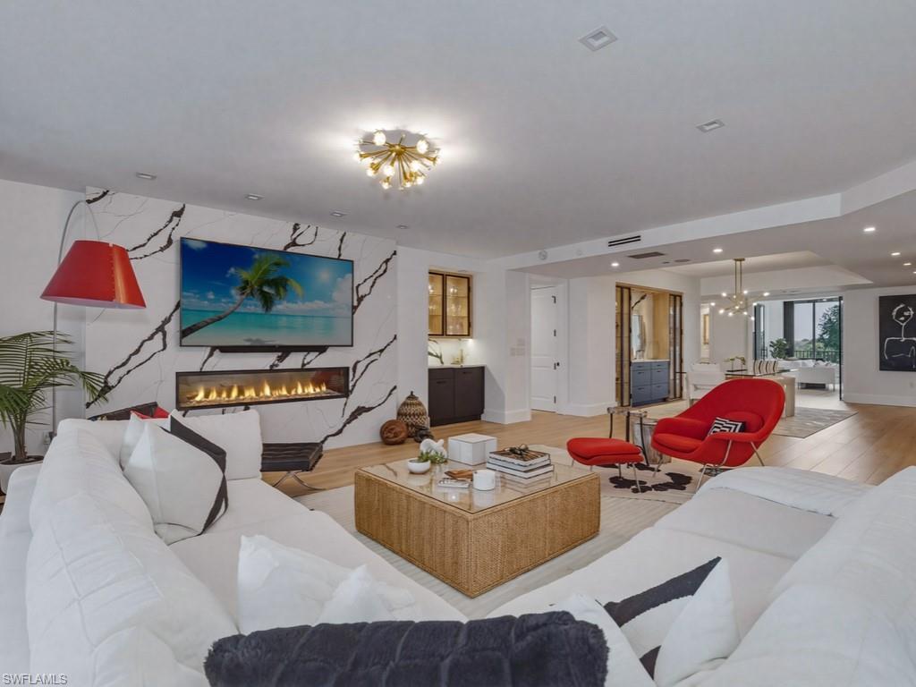 Living room with a premium fireplace, a chandelier, and light wood-style flooring