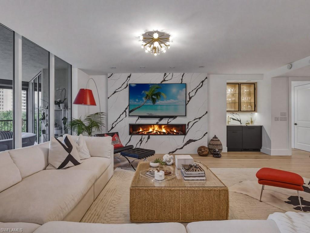 Living area featuring light wood flooring, a premium fireplace, and a marble accent wall