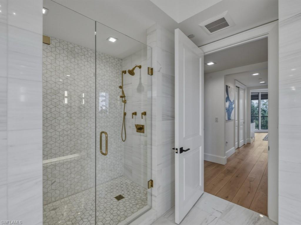 Bathroom with marble surround, light flooring, and recessed lighting