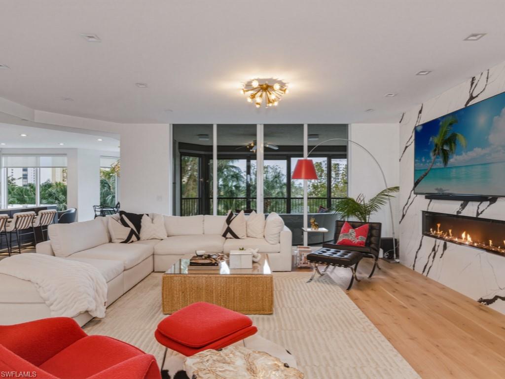 Living area with a high-end fireplace, French Oak wood floors, and a ceiling fan