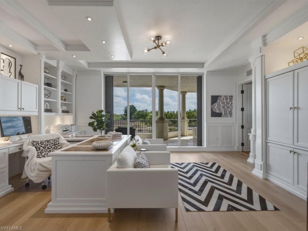 Living area featuring built in desk, light wood finished floors, beamed ceiling, crown molding, and recessed lighting