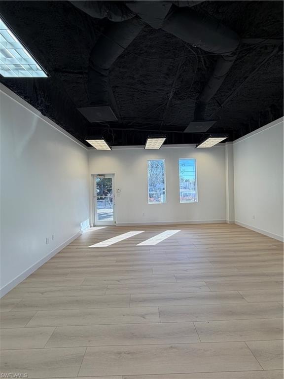 Spare room featuring light wood finished floors and baseboards