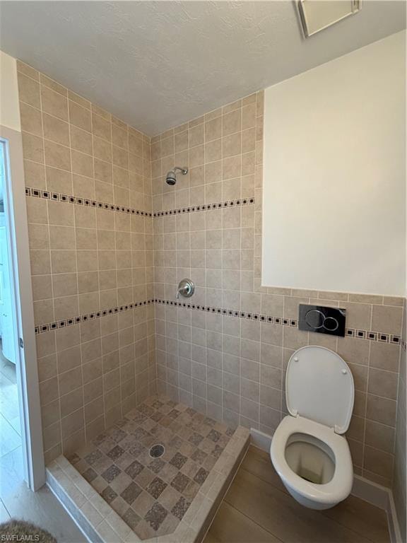 Full bath featuring a shower stall and tile walls