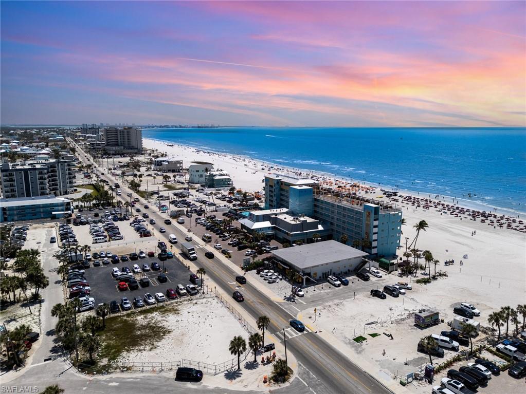 Aerial view at dusk of view of water and beach and a view of city