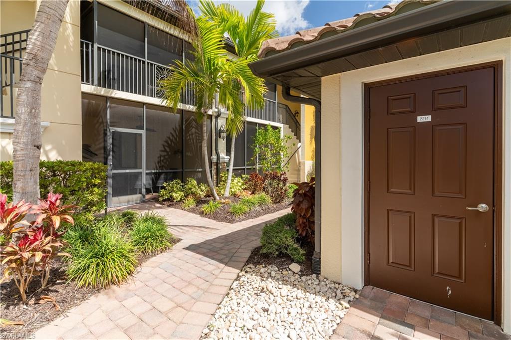 Doorway to property with stucco siding, a sunroom, and a tiled roof