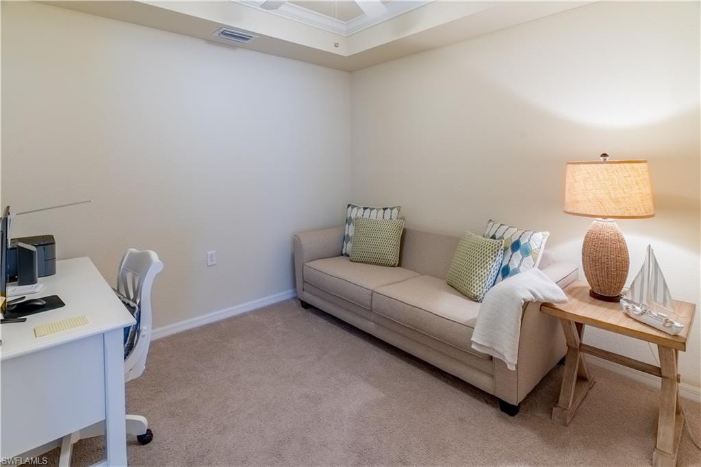 Home office with light carpet and a ceiling fan