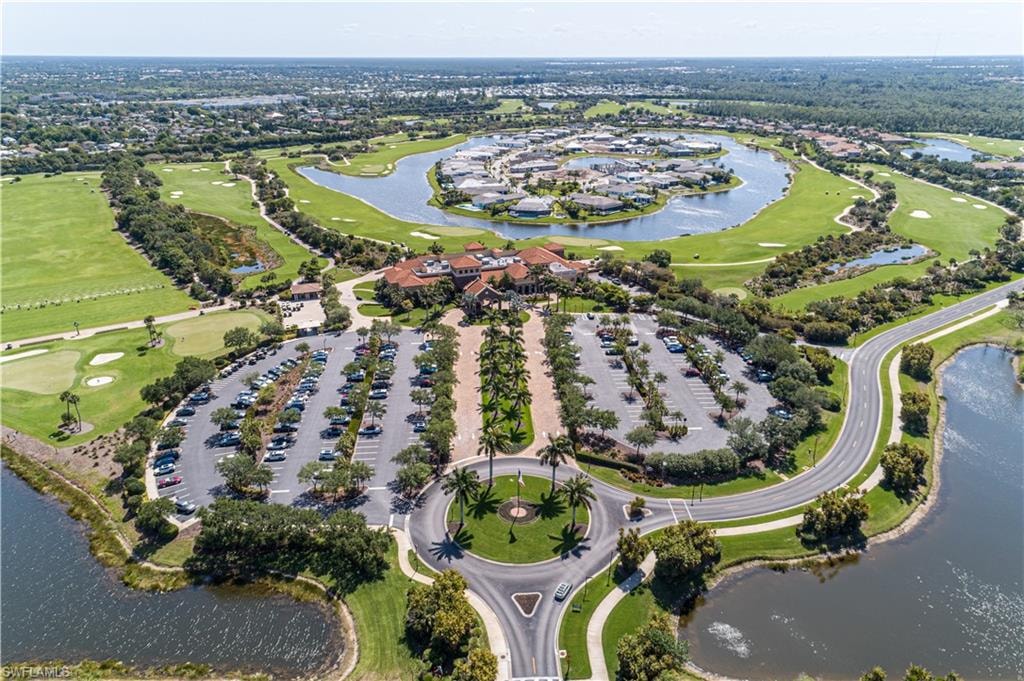 Aerial view of property and surrounding area with a nearby body of water, a local golf course, and nearby suburban area