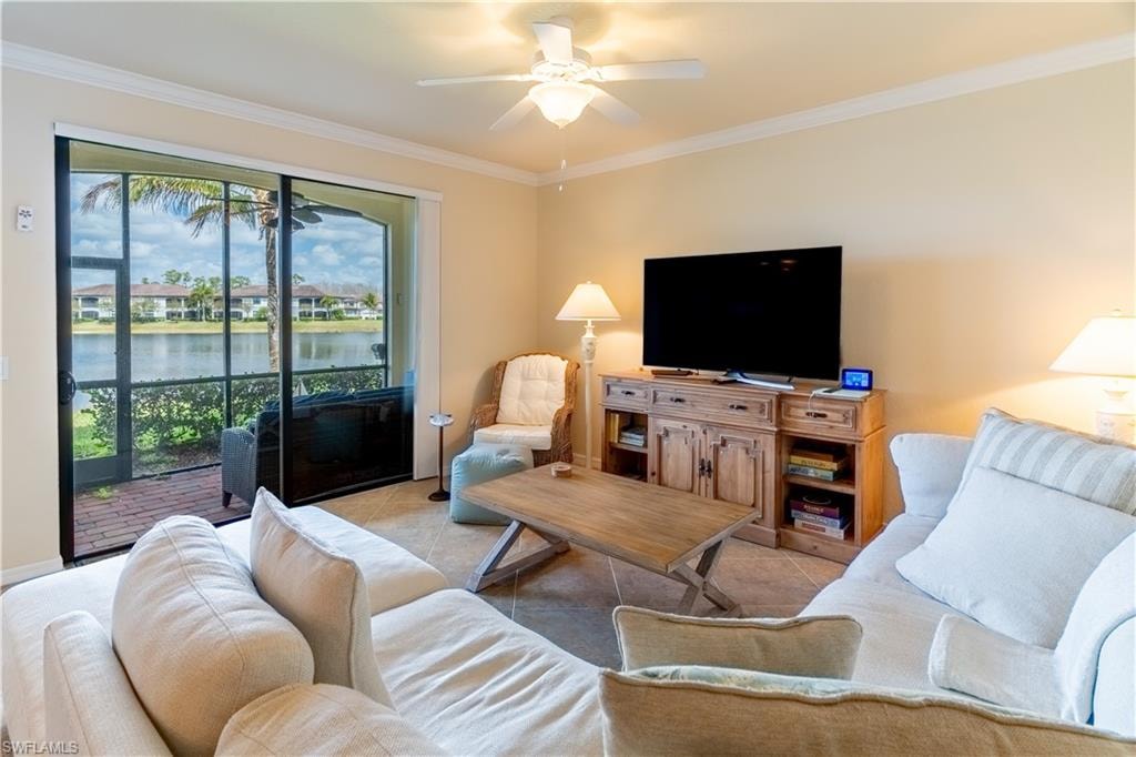 Living area featuring light tile patterned flooring, a ceiling fan, and ornamental molding