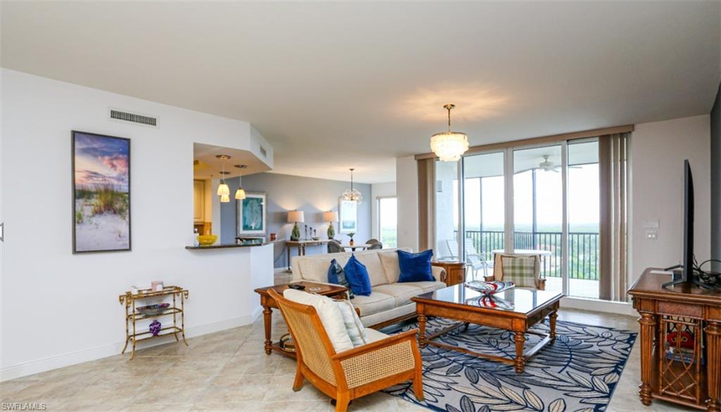 Living area featuring baseboards, visible vents, and a wall of windows