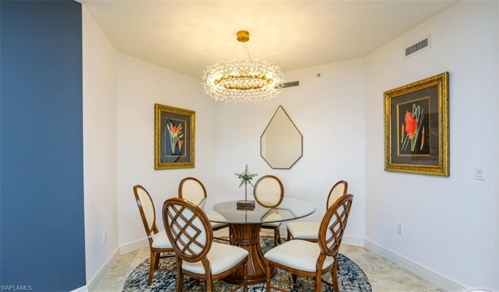 Dining room featuring baseboards, visible vents, and an inviting chandelier