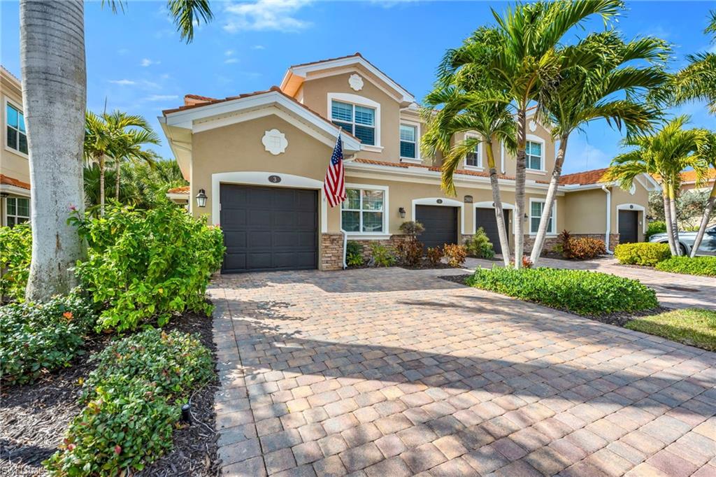 Mediterranean / spanish house featuring stucco siding, decorative driveway, stone siding, and a tiled roof