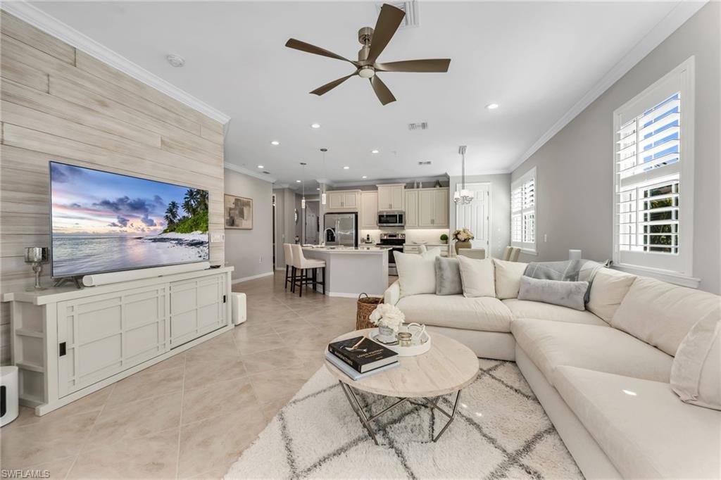 Living room with recessed lighting, a ceiling fan, crown molding, light tile patterned floors, and an accent wall
