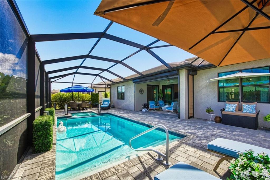 Integrated pool / spa with an outdoor living / dining area, a patio area, a sunroom, and glass enclosure