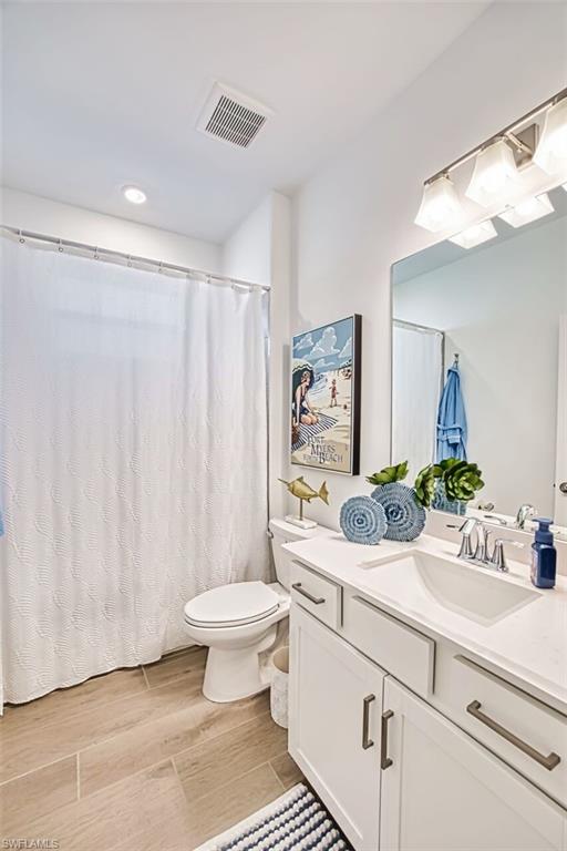 Bathroom with vanity, light wood-type flooring, a shower with curtain, and recessed lighting