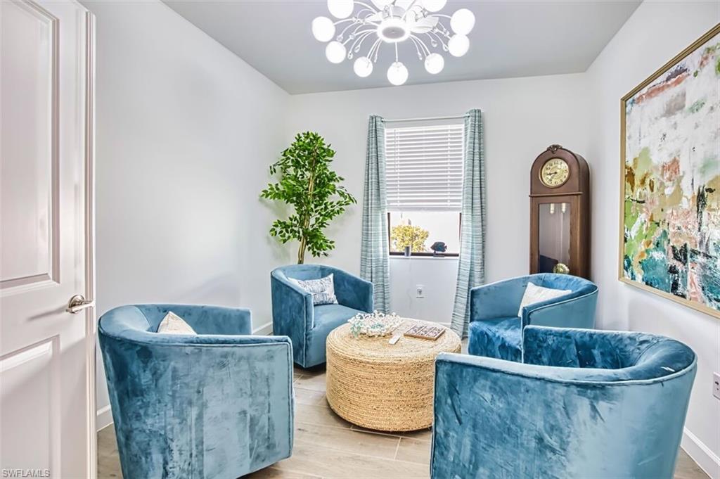 Sitting room featuring suspended lighting and wood tiled floors