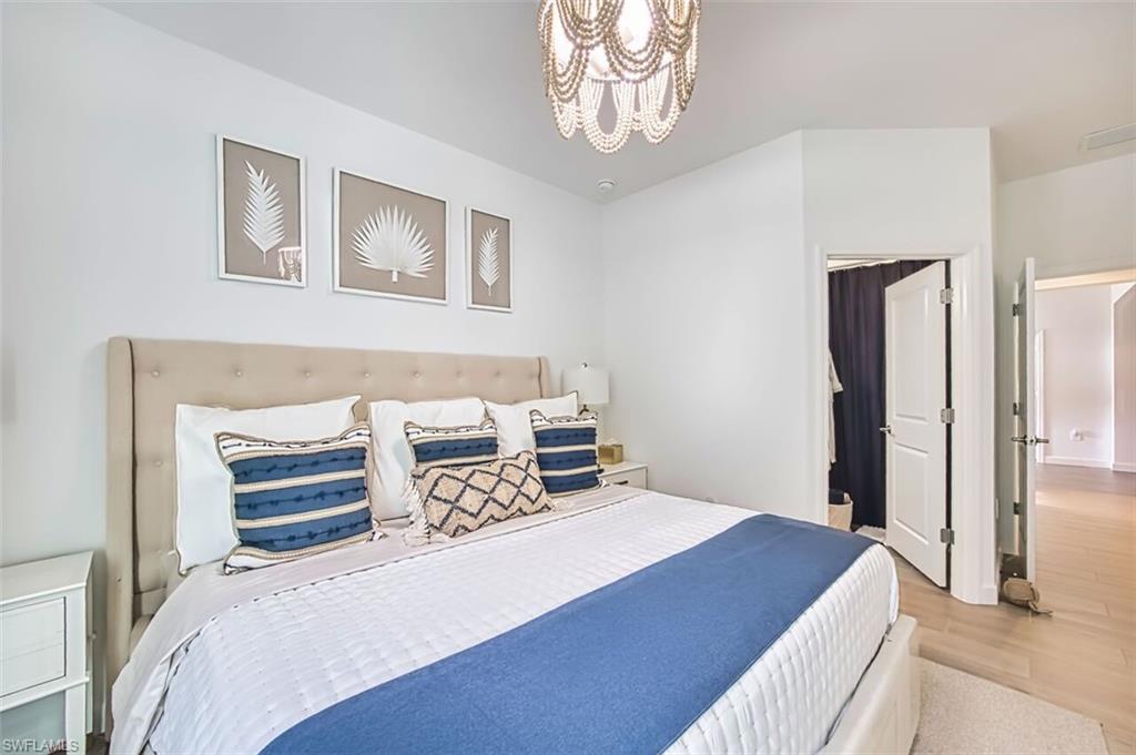 Bedroom featuring wood finished floors and hanging lights