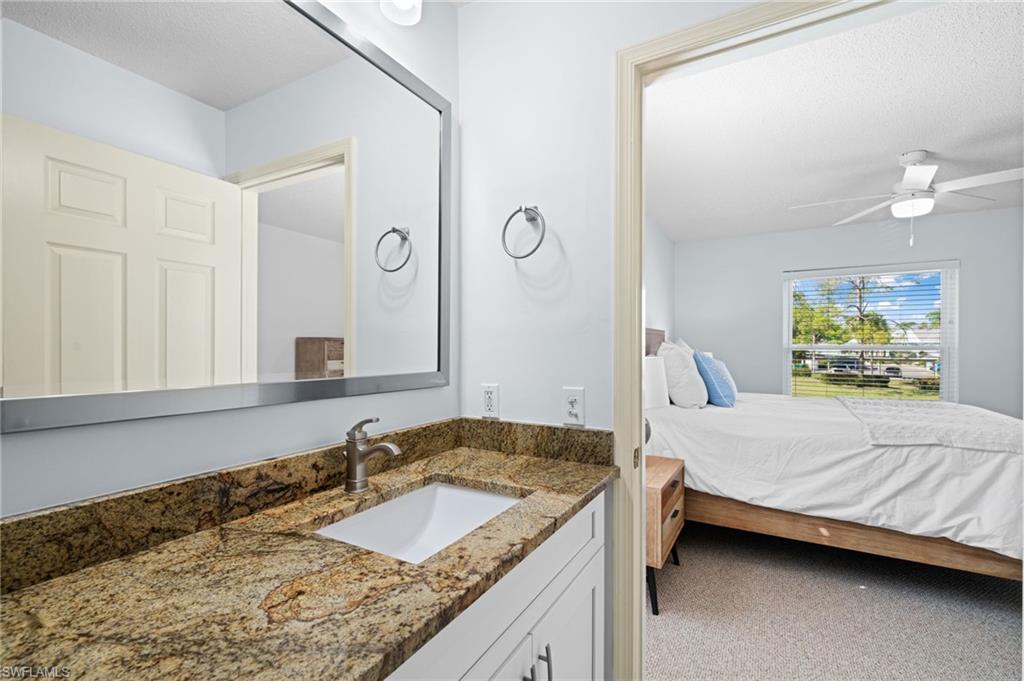 Ensuite bathroom featuring vanity, a textured ceiling, and ceiling fan