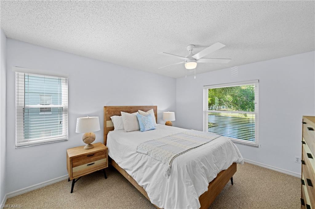 Carpeted bedroom with a ceiling fan and a textured ceiling