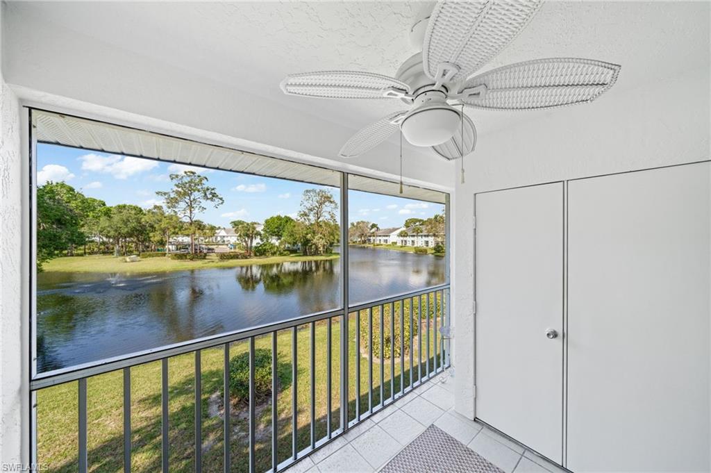 Unfurnished sunroom featuring a ceiling fan and a water view