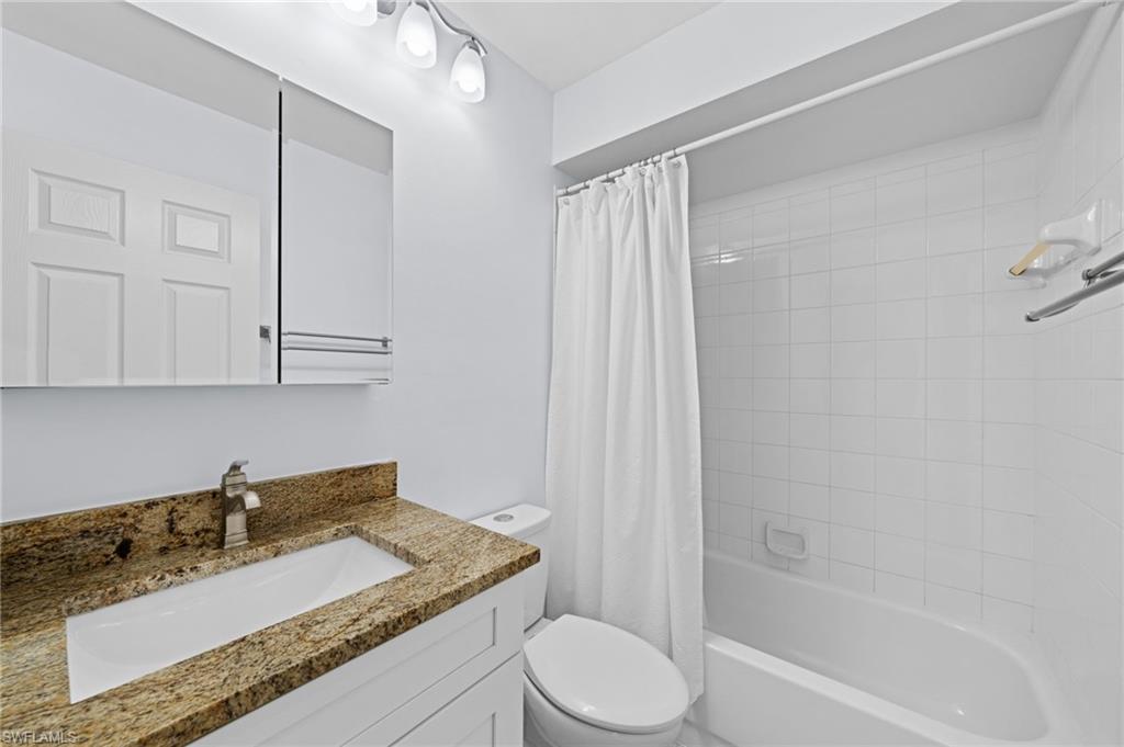 Full bath featuring shower / bath combination with curtain and vanity