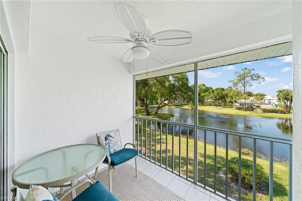 Unfurnished sunroom featuring ceiling fan, a balcony, and a water view