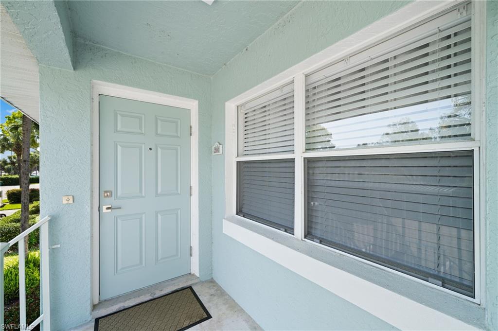 Doorway to property featuring stucco siding