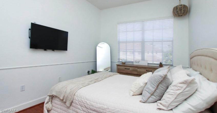 Bedroom with wood finished floors and baseboards