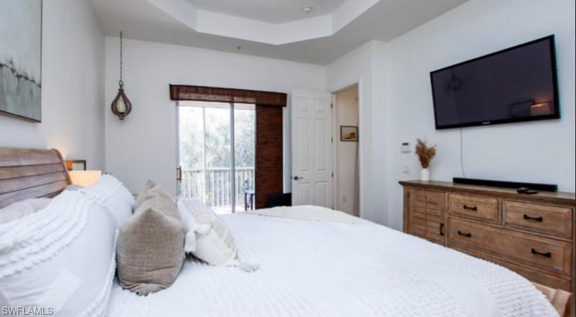 Bedroom with a raised ceiling and access to exterior