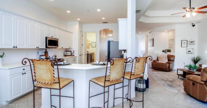 Kitchen with white cabinetry, light countertops, a peninsula, stainless steel appliances, and recessed lighting