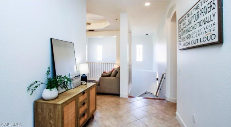 Foyer with arched walkways, recessed lighting, and light tile patterned floors