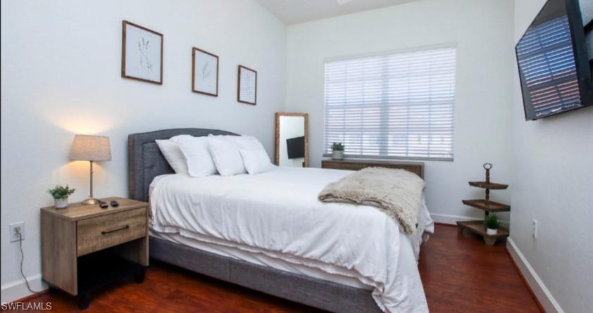 Bedroom featuring dark wood finished floors and baseboards