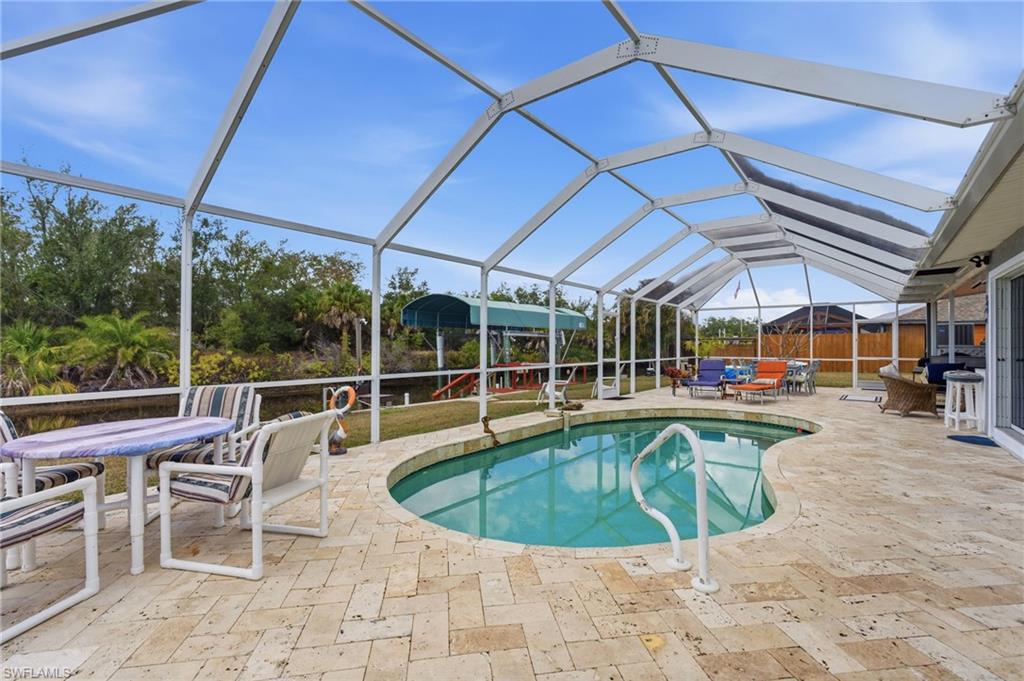 Outdoor pool featuring outdoor lounge area, a lanai, a sunroom, and a patio area