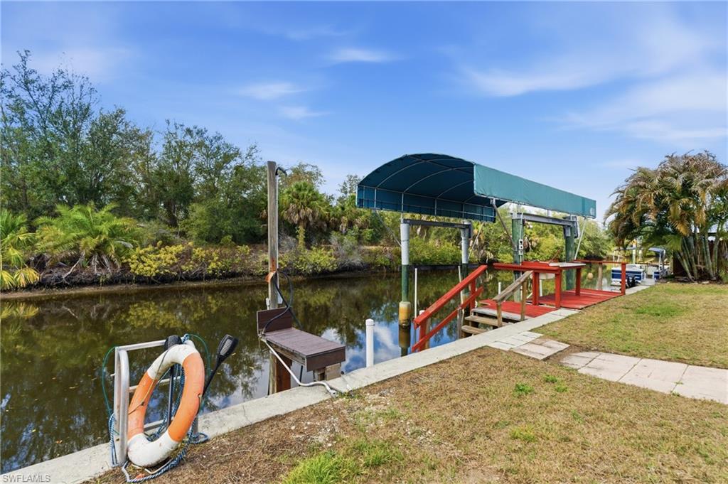 Dock area featuring a water view and a yard