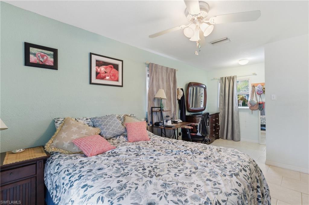 Bedroom with light tile patterned floors and ceiling fan