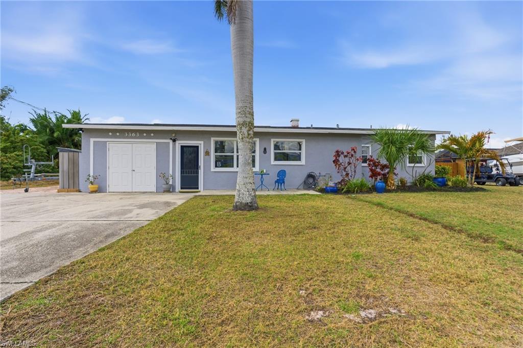 Single story home featuring stucco siding, a front lawn, and a patio
