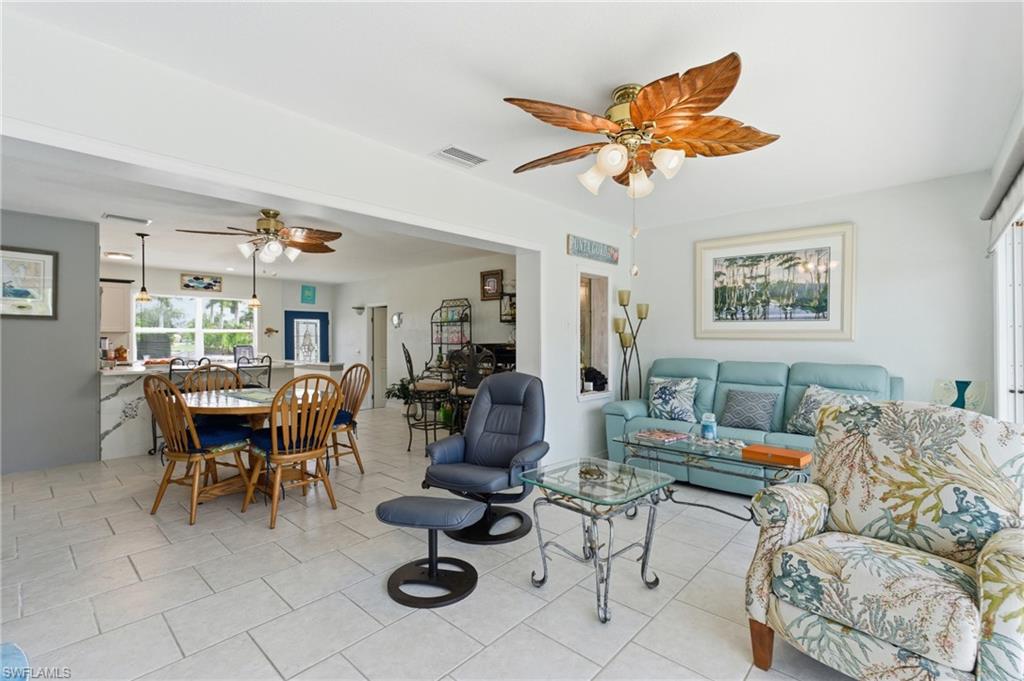 Living room featuring a ceiling fan and light tile patterned floors